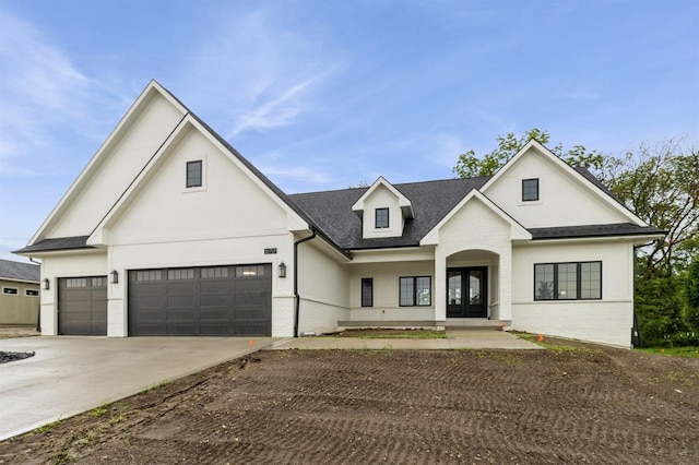 570 El Dorado Ct, Waukee, IA 50263 - modern inspired farmhouse featuring brick siding, french doors, concrete driveway, a shingled roof, and stucco siding
