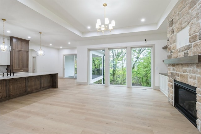 570 El Dorado Ct, Waukee, IA 50263 - kitchen featuring a chandelier, open floor plan, a fireplace, light wood-style flooring, and recessed lighting