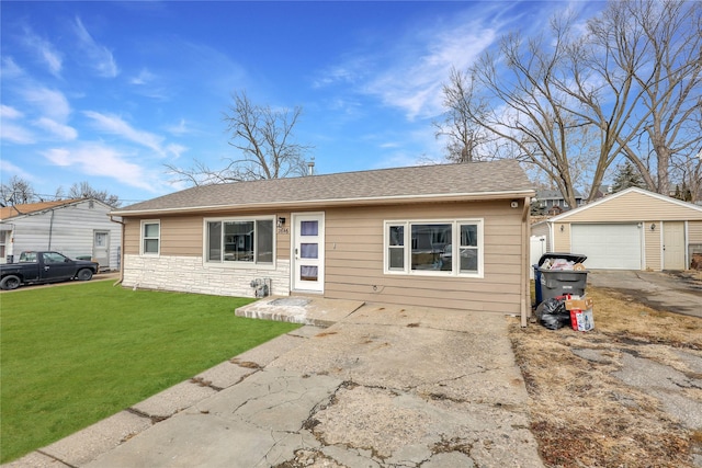 view of front of home featuring an outbuilding, a shingled roof, a front yard, a garage, and stone siding