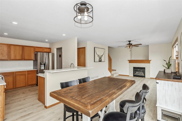 dining space with light wood-type flooring, a fireplace, visible vents, and recessed lighting