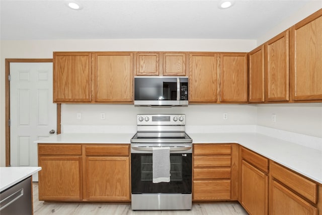 kitchen featuring appliances with stainless steel finishes, recessed lighting, light countertops, and light wood-style floors