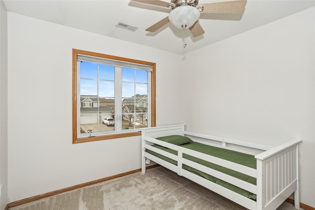 bedroom with carpet floors, visible vents, baseboards, and a ceiling fan