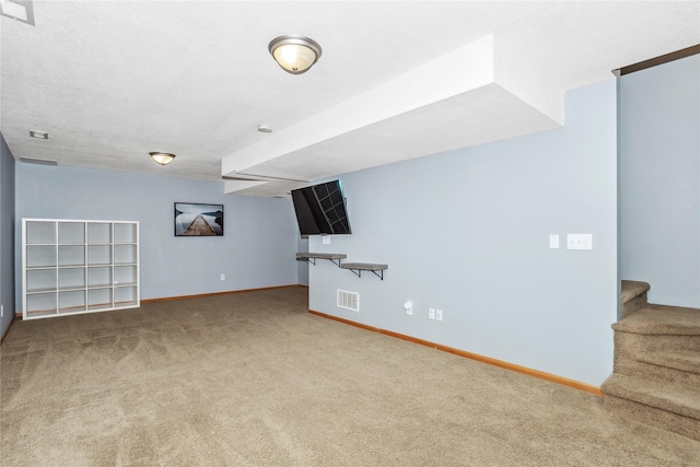 basement featuring carpet floors, baseboards, stairs, and visible vents