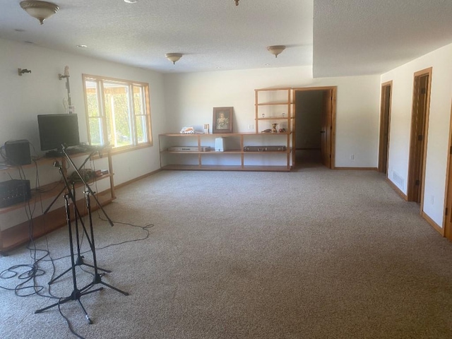 unfurnished office featuring carpet, baseboards, and a textured ceiling