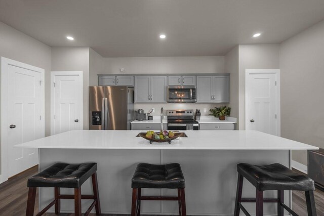 kitchen with appliances with stainless steel finishes, gray cabinets, light countertops, and a spacious island