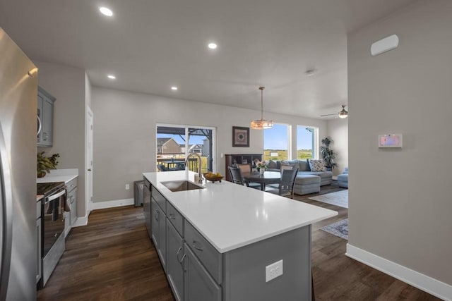 kitchen with light countertops, an island with sink, a sink, and stainless steel appliances