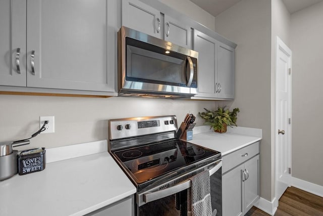 kitchen featuring appliances with stainless steel finishes, light countertops, and gray cabinetry