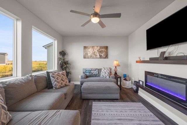 living room featuring a ceiling fan, baseboards, and dark wood-type flooring