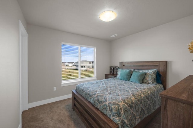 bedroom featuring dark colored carpet, visible vents, and baseboards