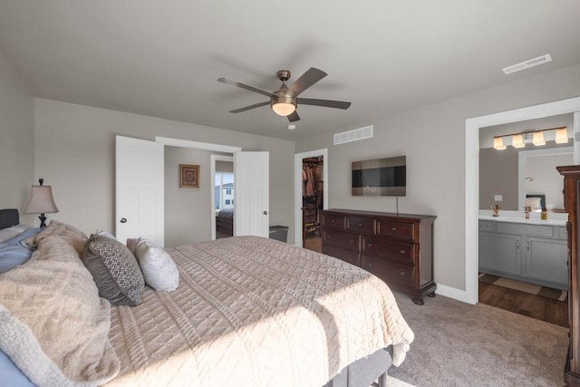 bedroom with a spacious closet, a closet, carpet flooring, and visible vents