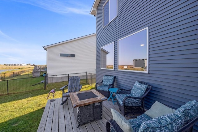 wooden deck featuring a yard, fence, and an outdoor living space with a fire pit