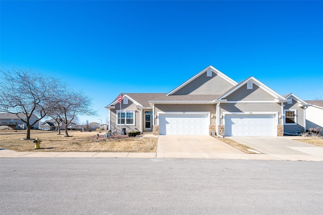 view of front of home featuring a garage, concrete driveway, and stone siding