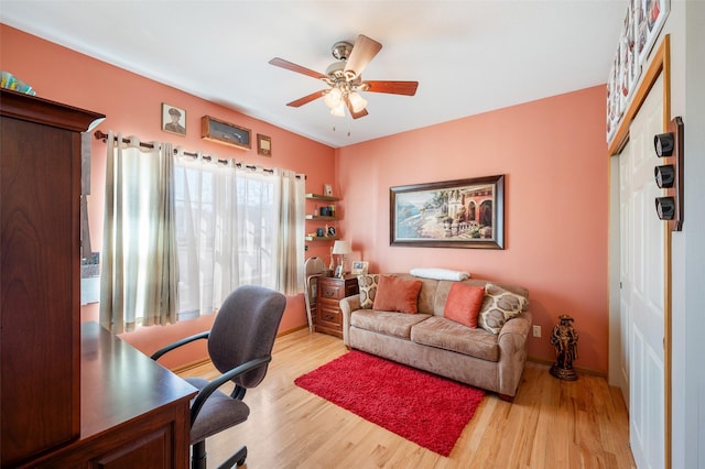 home office with light wood-style floors and ceiling fan