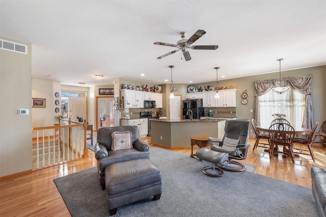 living area with recessed lighting, visible vents, light wood-style floors, ceiling fan, and baseboards