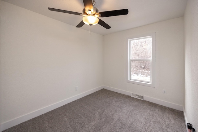 carpeted spare room with a ceiling fan, visible vents, and baseboards