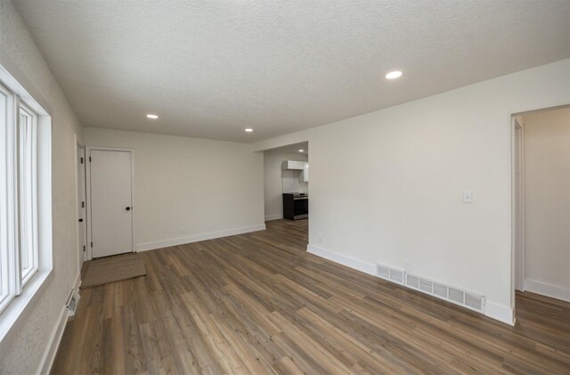 empty room featuring baseboards, visible vents, wood finished floors, and recessed lighting