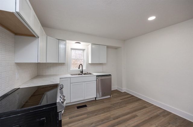 kitchen with a sink, light countertops, stainless steel dishwasher, decorative backsplash, and electric range oven