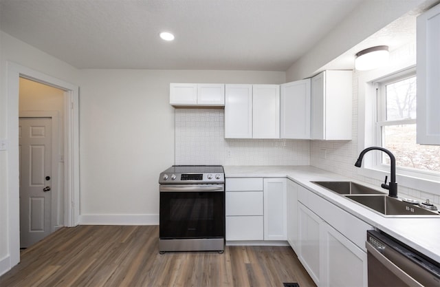 kitchen featuring a sink, white cabinetry, light countertops, appliances with stainless steel finishes, and dark wood finished floors