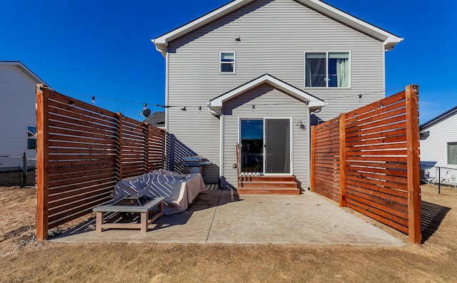 rear view of property with entry steps, fence, and a patio