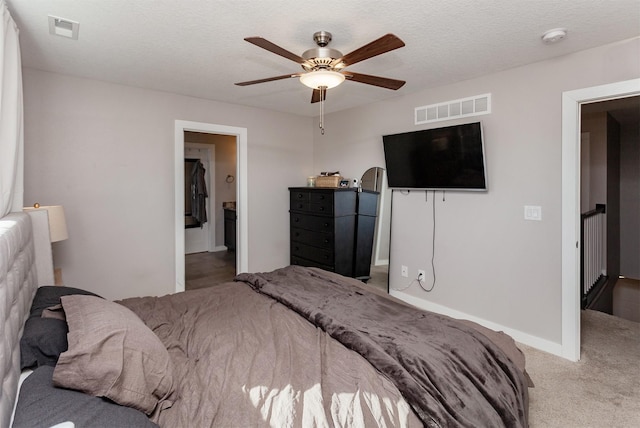 carpeted bedroom featuring a textured ceiling, ceiling fan, visible vents, and baseboards