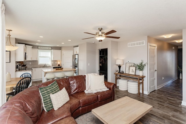 living area with dark wood finished floors, recessed lighting, visible vents, ceiling fan, and baseboards