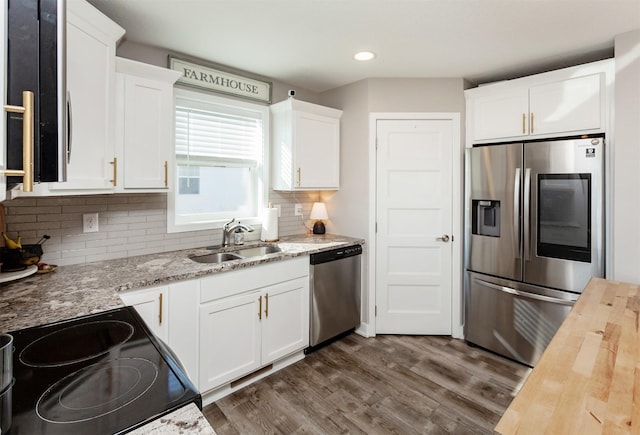 kitchen featuring dark wood-style flooring, stainless steel appliances, wooden counters, white cabinets, and a sink