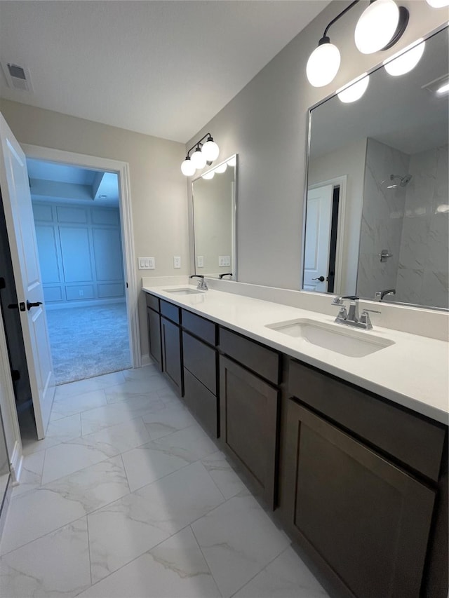 full bathroom featuring marble finish floor, visible vents, walk in shower, and a sink