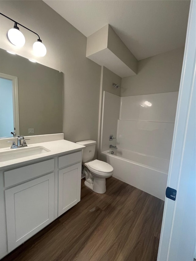 full bathroom with vanity, bathtub / shower combination, wood finished floors, and toilet