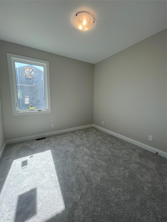 carpeted empty room with visible vents and baseboards