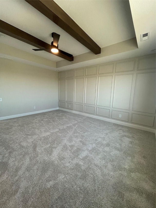 unfurnished bedroom featuring visible vents, carpet, beam ceiling, and a decorative wall