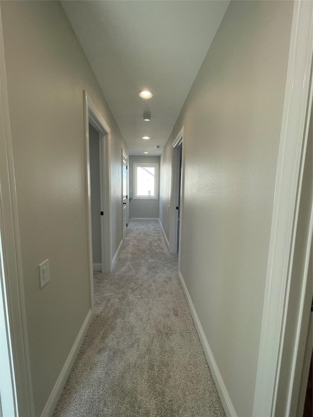 corridor featuring recessed lighting, light colored carpet, and baseboards