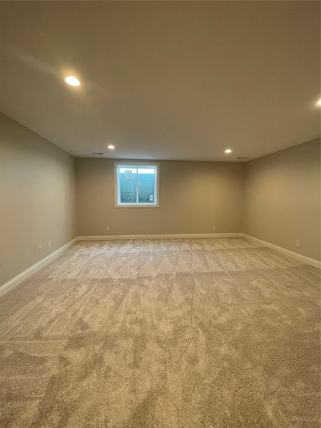 below grade area with light carpet, recessed lighting, and baseboards