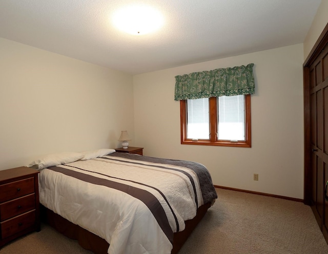 bedroom with light colored carpet and baseboards