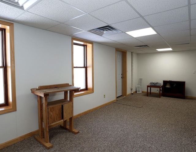 interior space featuring carpet, visible vents, a drop ceiling, and baseboards