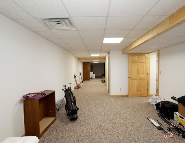 interior space featuring carpet flooring, visible vents, baseboards, and a drop ceiling