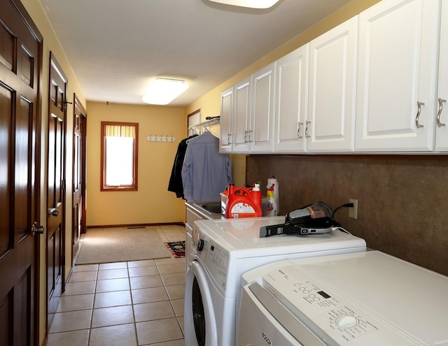 clothes washing area with light tile patterned floors, baseboards, cabinet space, and separate washer and dryer