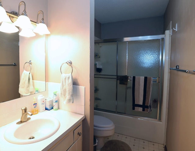 full bathroom featuring backsplash, bath / shower combo with glass door, toilet, tile patterned floors, and vanity