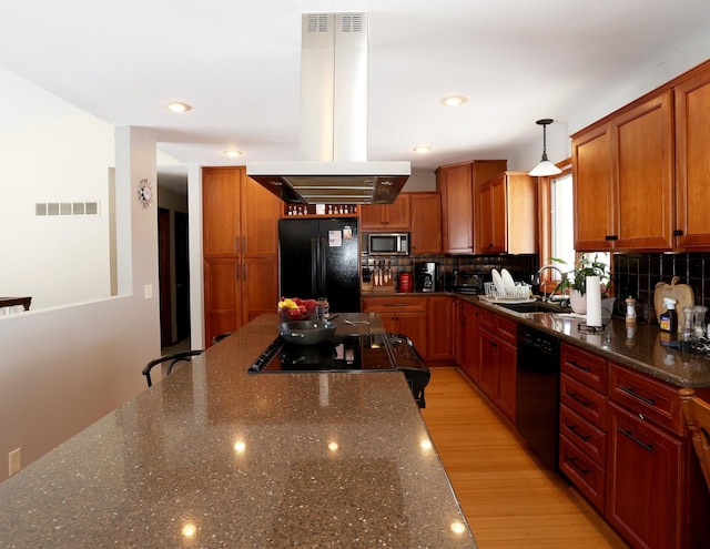 kitchen with visible vents, island exhaust hood, freestanding refrigerator, dishwasher, and stainless steel microwave