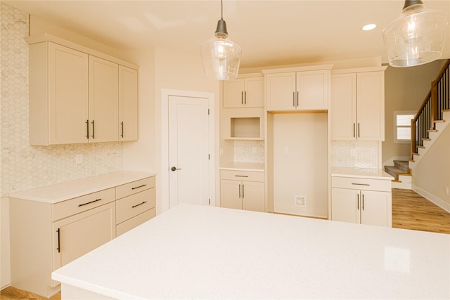 kitchen featuring light countertops, decorative backsplash, white cabinetry, and pendant lighting