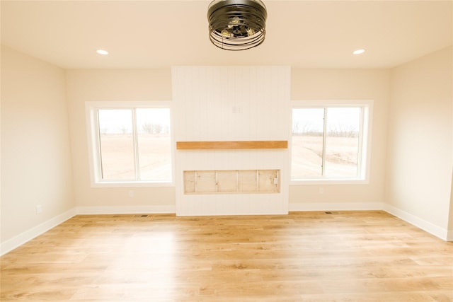 unfurnished living room featuring light wood finished floors, recessed lighting, and baseboards