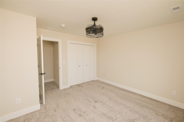 unfurnished bedroom with baseboards, visible vents, and light colored carpet