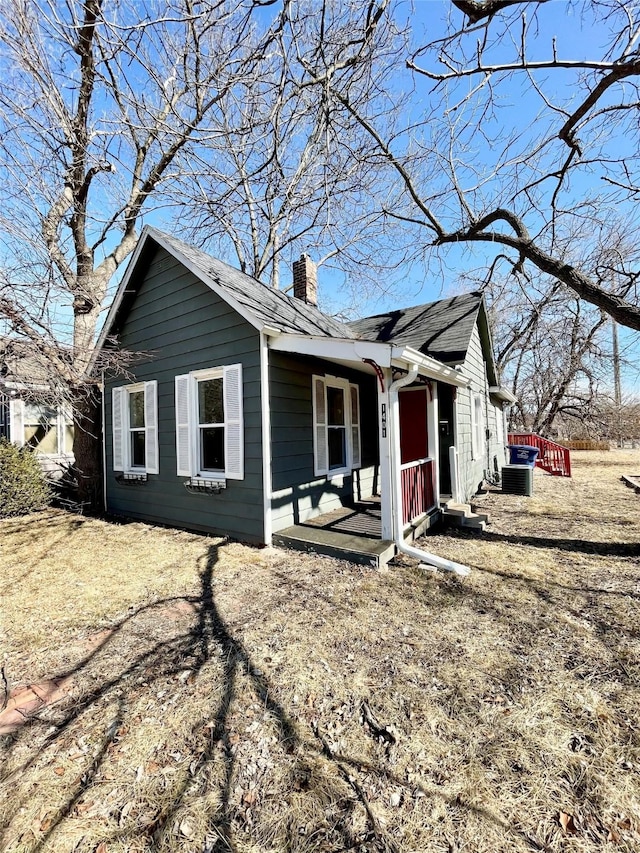 view of front of house with a shingled roof and a chimney