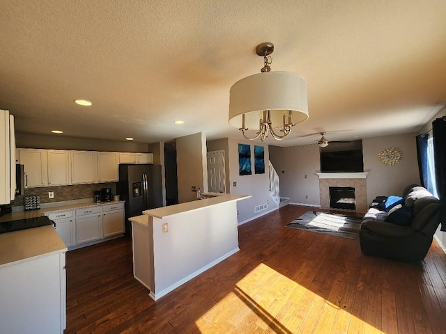 kitchen with open floor plan, hanging light fixtures, light countertops, and white cabinets