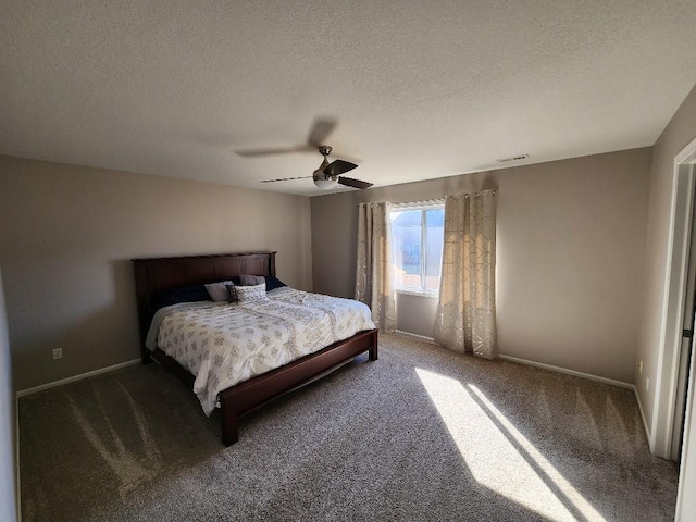 bedroom featuring a textured ceiling, dark carpet, and baseboards