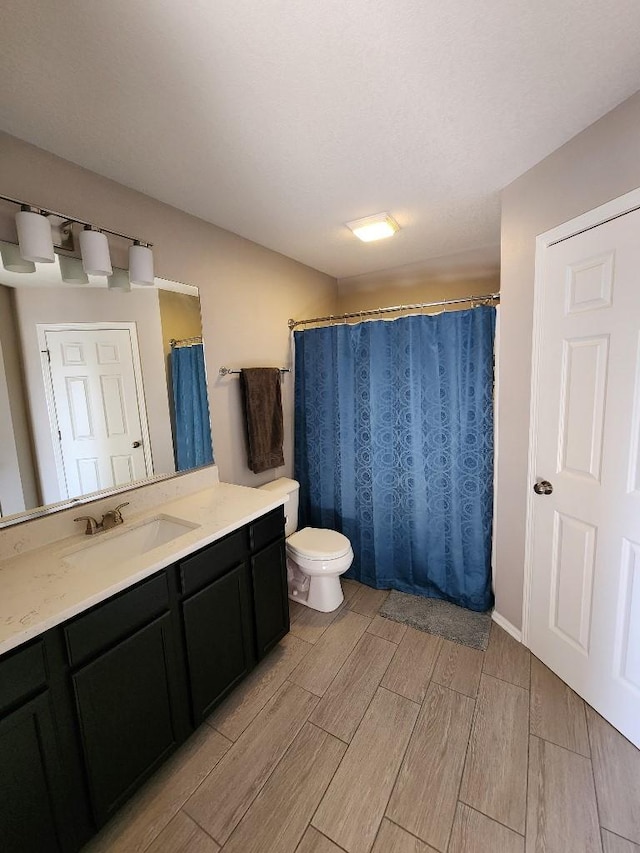 full bath with toilet, wood finish floors, vanity, and a shower with curtain