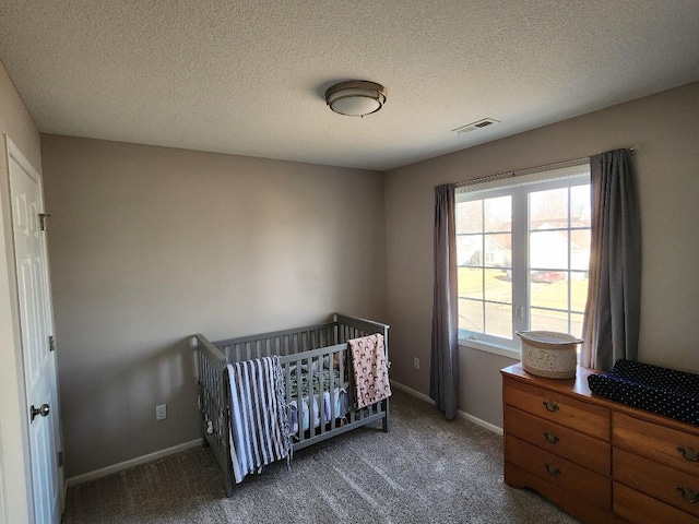 bedroom featuring baseboards, visible vents, dark colored carpet, and a textured ceiling