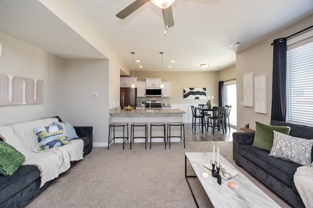 living area featuring recessed lighting, baseboards, ceiling fan, and light colored carpet