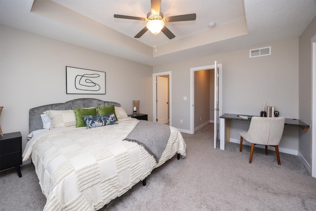 bedroom featuring baseboards, visible vents, a raised ceiling, and carpet flooring