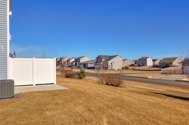 view of yard with a residential view, fence, and cooling unit