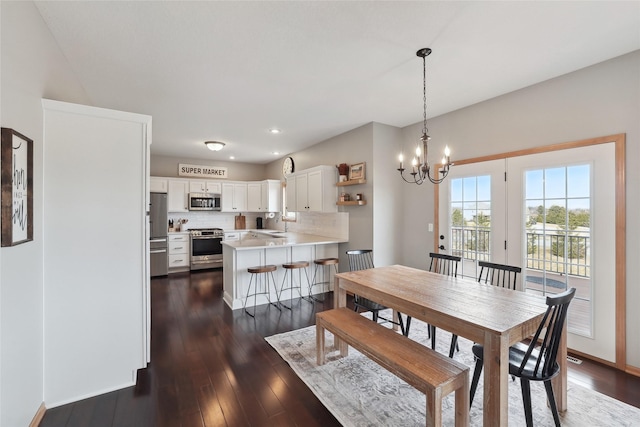 dining area featuring recessed lighting, dark wood-style flooring, and an inviting chandelier